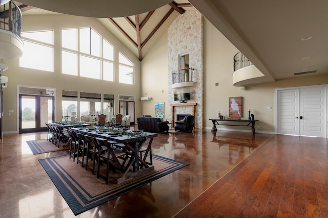 dining room with a towering ceiling and a fireplace