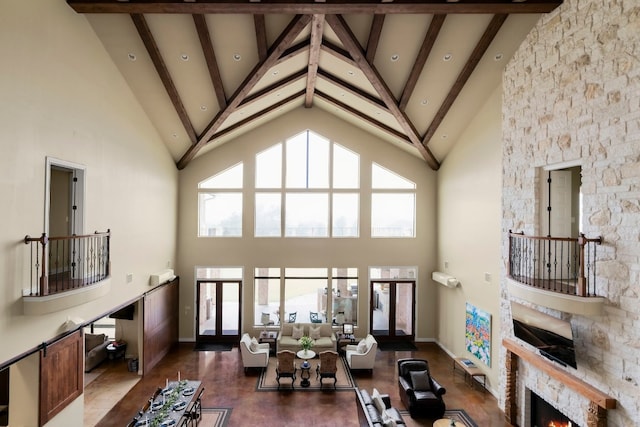 living room with beam ceiling and high vaulted ceiling