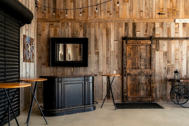 interior space with concrete flooring and wood walls