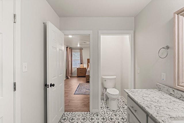 bathroom featuring vanity, wood-type flooring, and toilet