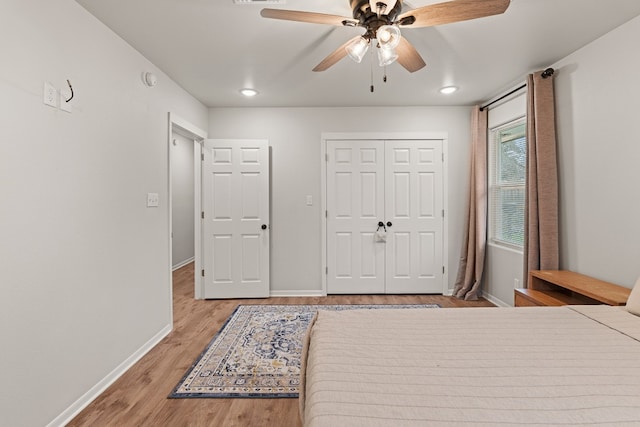 bedroom with ceiling fan, light wood-type flooring, and a closet