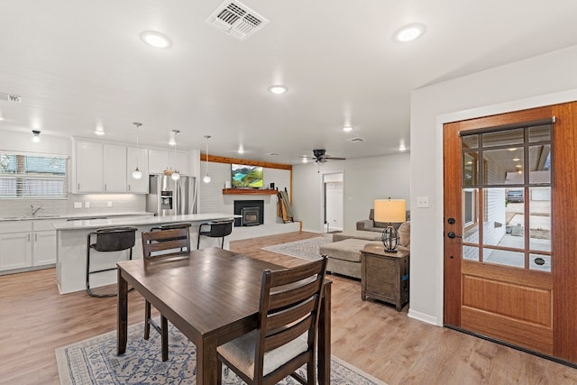 dining room with sink, ceiling fan, and light hardwood / wood-style flooring