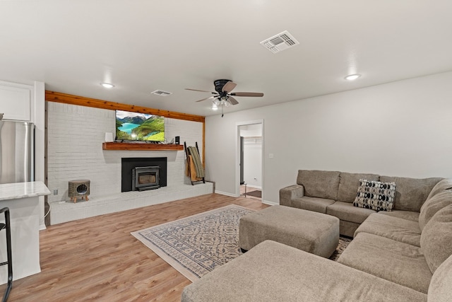 living room with ceiling fan and light hardwood / wood-style flooring