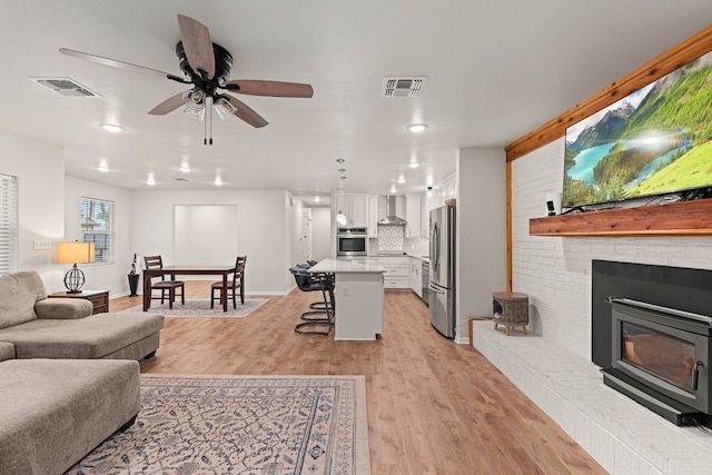 living room with ceiling fan and light hardwood / wood-style floors