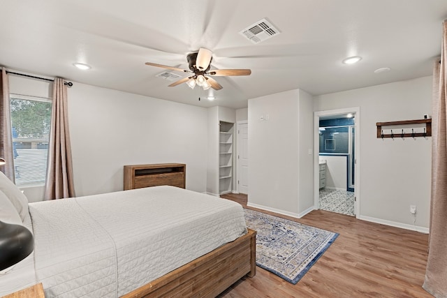 bedroom with connected bathroom, light hardwood / wood-style floors, and ceiling fan