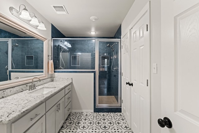 bathroom featuring an enclosed shower, vanity, and tile patterned flooring