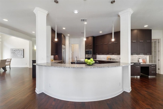 kitchen featuring pendant lighting, light stone counters, and kitchen peninsula