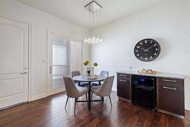 dining area featuring dark wood-type flooring, wine cooler, and an inviting chandelier