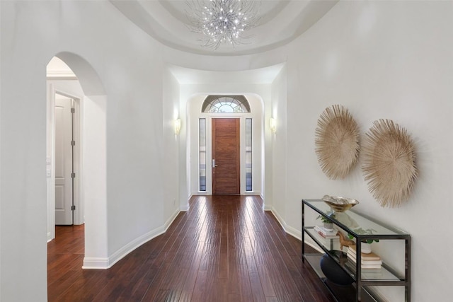 entrance foyer with dark hardwood / wood-style flooring and a notable chandelier