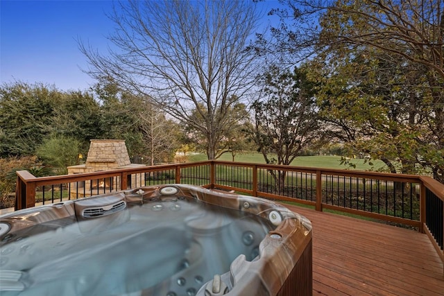 deck featuring a fireplace and a hot tub