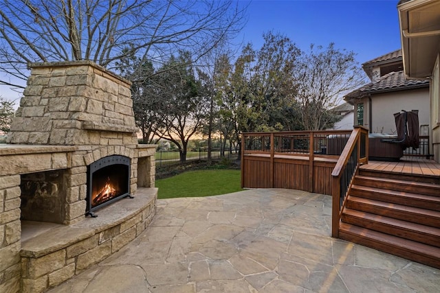 patio terrace at dusk with an outdoor stone fireplace