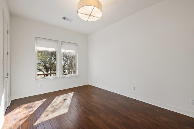 spare room featuring dark wood-type flooring