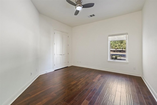 empty room featuring ceiling fan and dark hardwood / wood-style flooring