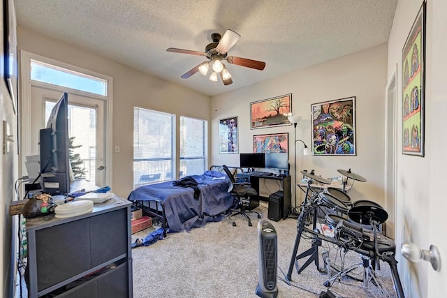 bedroom with ceiling fan, carpet floors, and a textured ceiling