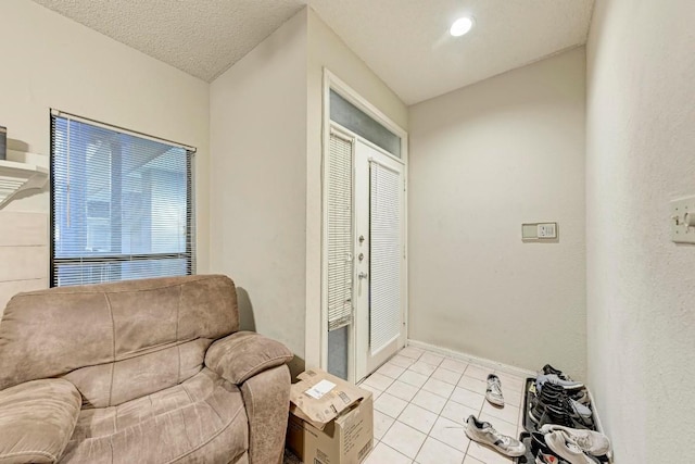 living area with light tile patterned flooring and a textured ceiling