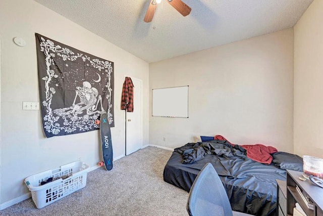 bedroom with ceiling fan, carpet flooring, and a textured ceiling