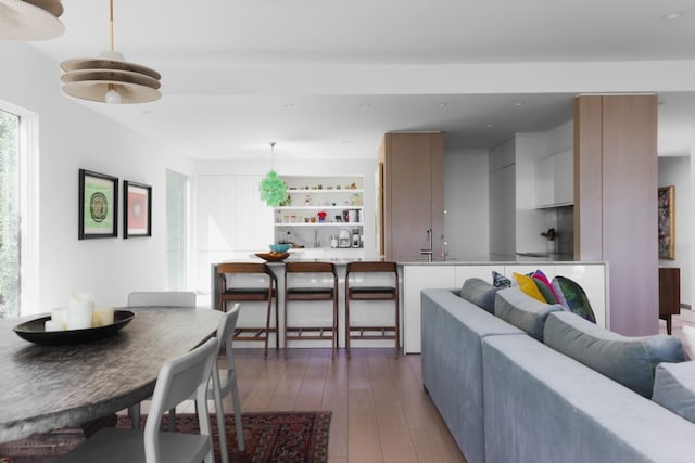 living room featuring dark wood-type flooring and bar area