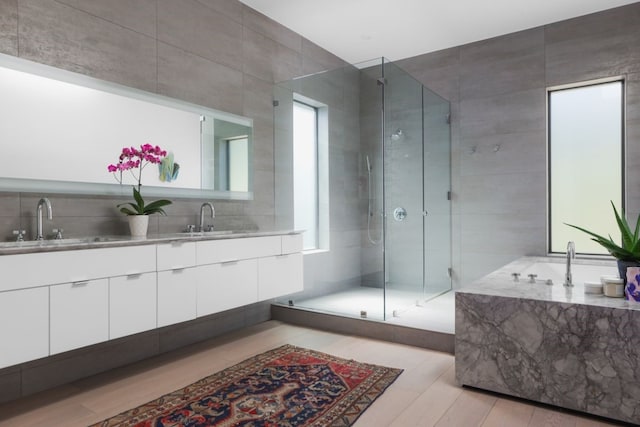 bathroom with tasteful backsplash, vanity, an enclosed shower, and tile walls