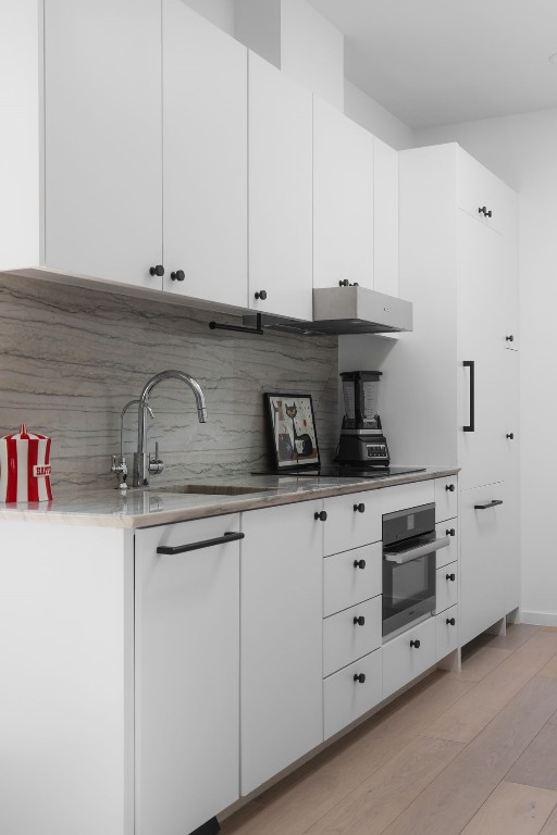 kitchen with white cabinetry and stainless steel oven