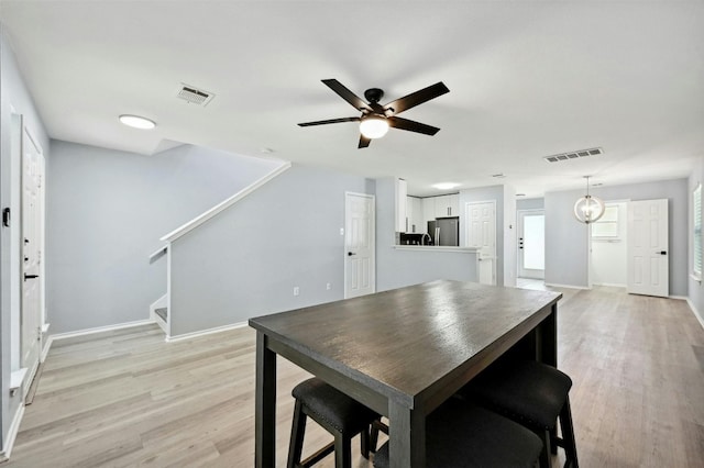 dining area with ceiling fan and light hardwood / wood-style floors