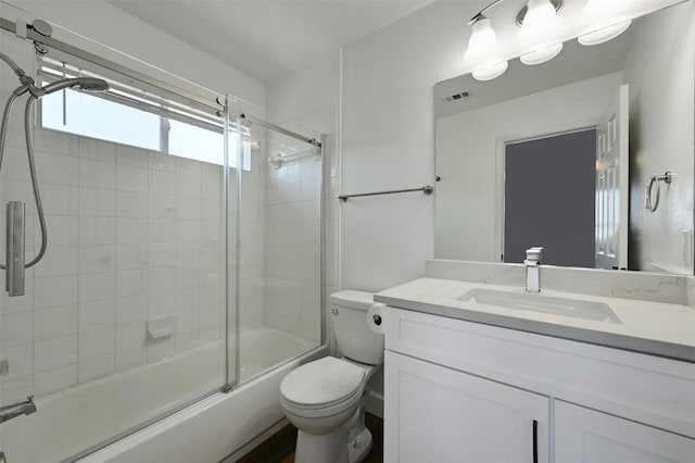 full bathroom with vanity, shower / bath combination with glass door, and toilet