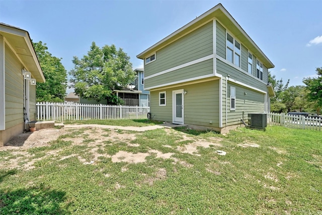 rear view of house with a yard and central AC unit