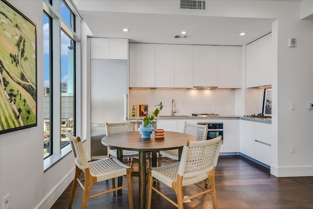 kitchen with white cabinetry, sink, backsplash, and dark wood-type flooring