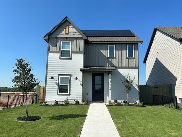 view of front of house with a front lawn and solar panels