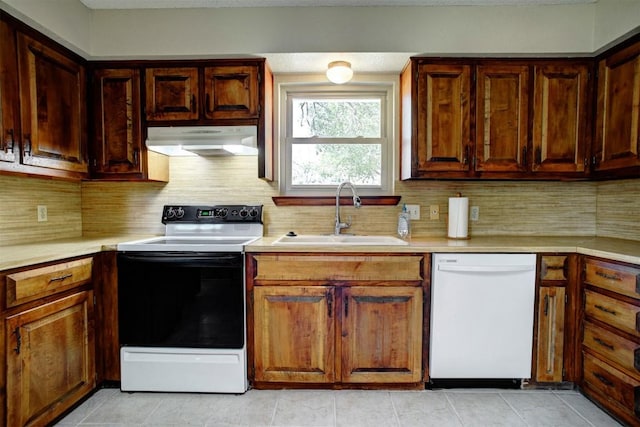 kitchen featuring tasteful backsplash, sink, light tile patterned floors, electric range, and white dishwasher