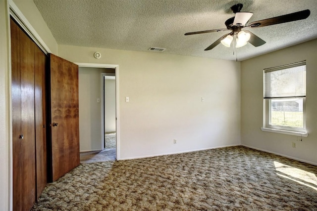 interior space featuring ceiling fan, carpet flooring, a closet, and a textured ceiling