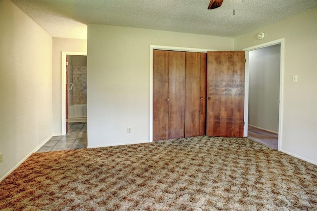 unfurnished bedroom featuring ceiling fan, light colored carpet, a textured ceiling, and a closet