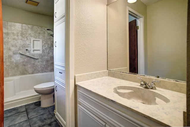 bathroom featuring tile patterned flooring, vanity, toilet, and a tile shower