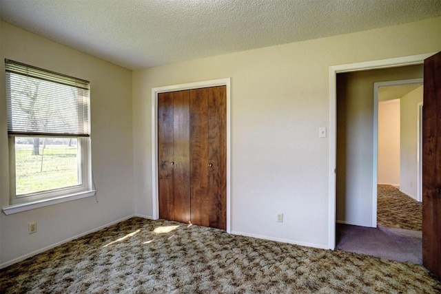 unfurnished bedroom with carpet flooring, a textured ceiling, and a closet