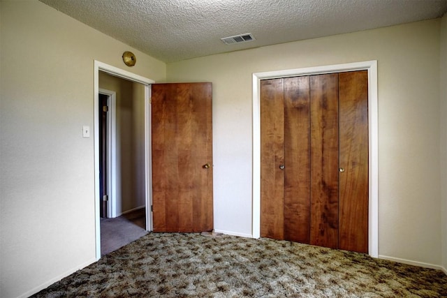 unfurnished bedroom with carpet floors, a closet, and a textured ceiling