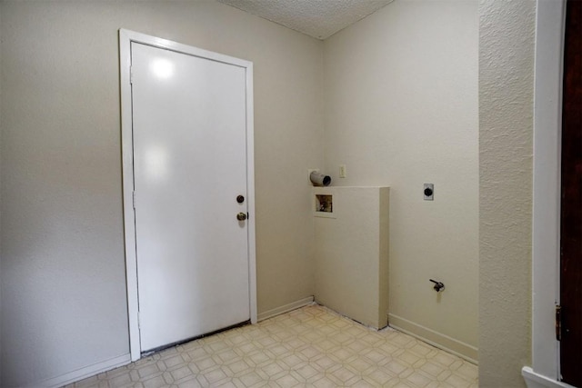 laundry area with electric dryer hookup, hookup for a washing machine, and a textured ceiling