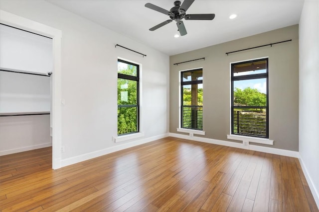 spare room with ceiling fan and light wood-type flooring