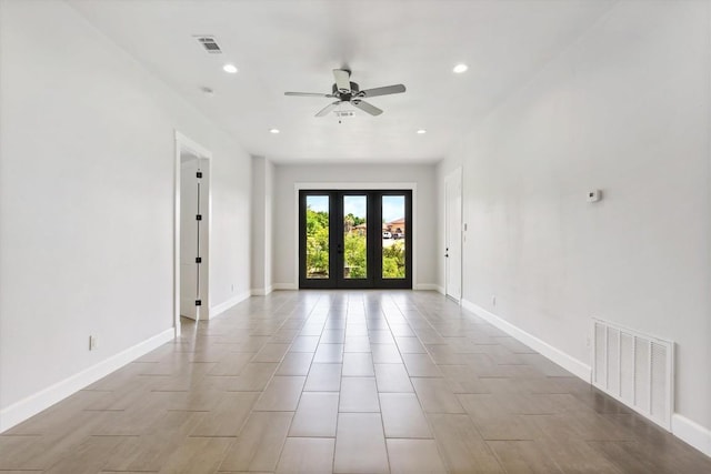 spare room with ceiling fan and french doors