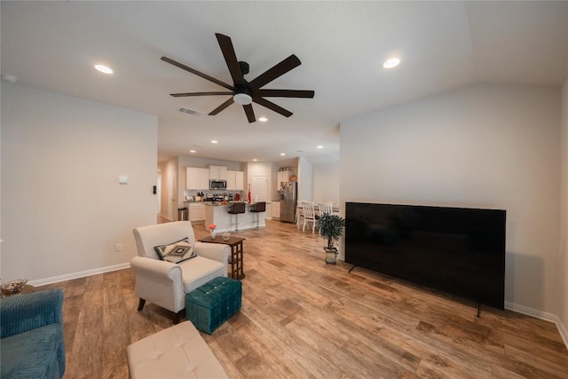 living room with ceiling fan and light wood-type flooring