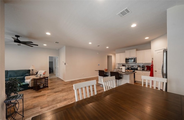 dining area with ceiling fan and light hardwood / wood-style flooring