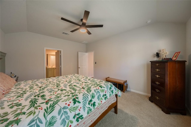 bedroom with light carpet, vaulted ceiling, ceiling fan, and ensuite bathroom