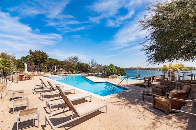 view of pool with a patio and a water view