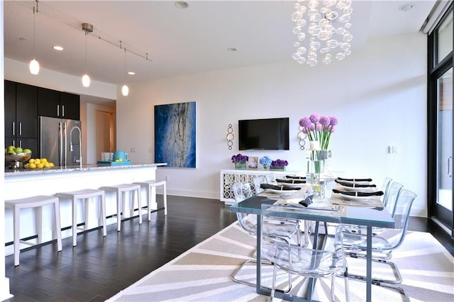 dining space with dark hardwood / wood-style flooring and a chandelier