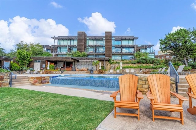 view of swimming pool with a yard and pool water feature