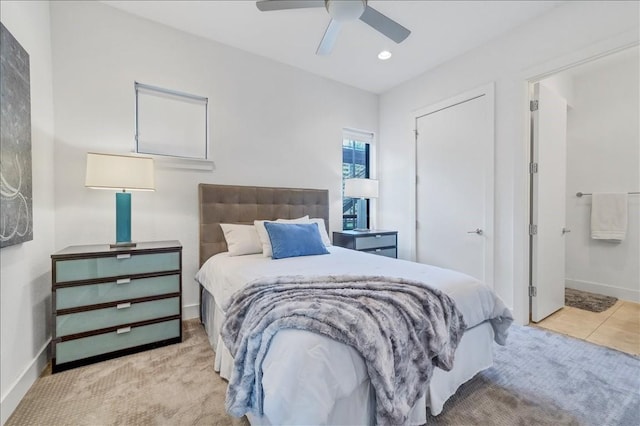 bedroom featuring connected bathroom, light carpet, and ceiling fan