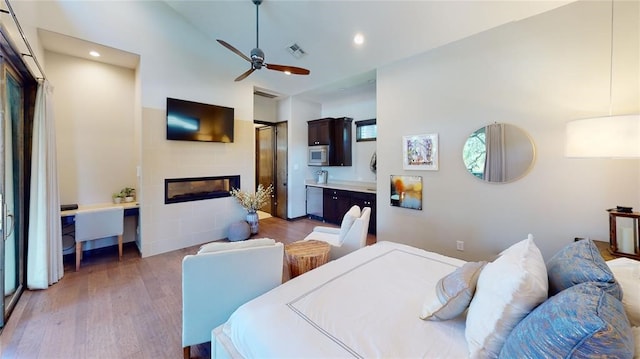 bedroom with ceiling fan, ensuite bathroom, and dark hardwood / wood-style flooring