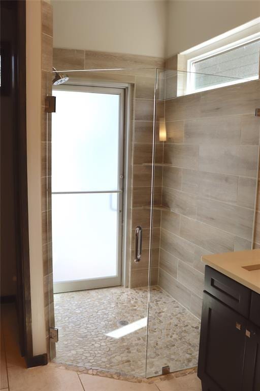 bathroom with a shower with door and vanity