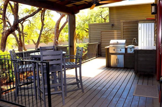 deck featuring ceiling fan and a grill