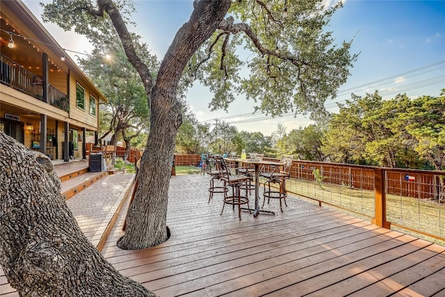 wooden terrace featuring a fenced backyard, outdoor dining area, and a yard