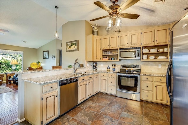 kitchen featuring sink, hanging light fixtures, kitchen peninsula, stainless steel appliances, and light stone countertops