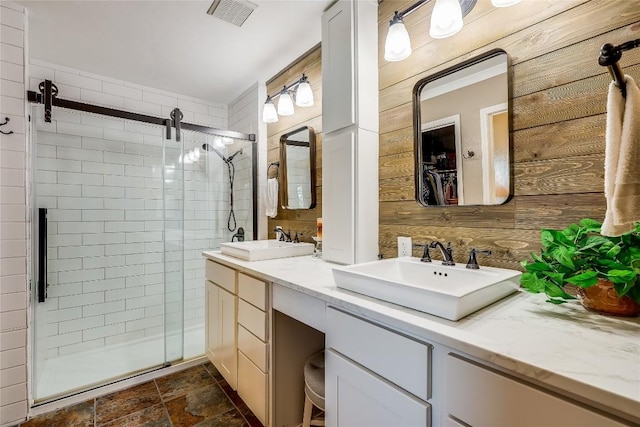 bathroom with vanity, an enclosed shower, and wood walls